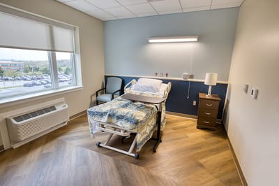 Private resident room with a hospital bed and seating