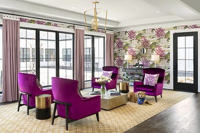 Bright common area with colorful chairs and a dog