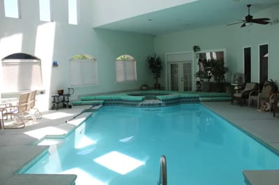 Indoor swimming pool surrounded by seating areas