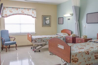 A shared resident room with two beds and a sitting area