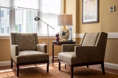 Cozy seating area with two chairs and lamp