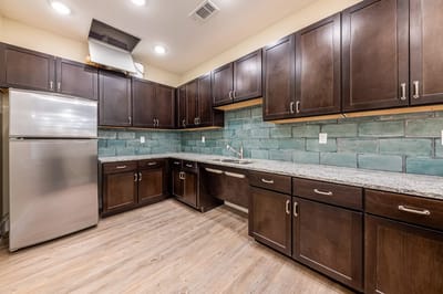 Modern kitchen space with dark cabinets and tile backsplash