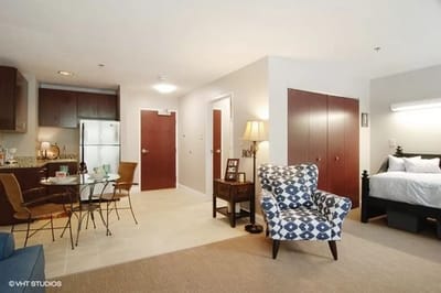 Interior view of a resident living space with a bed and seating area
