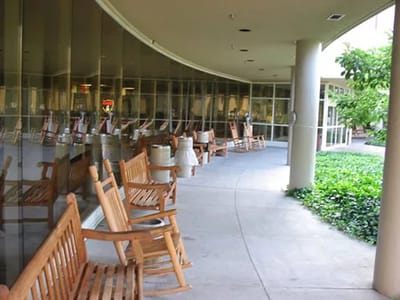 Outdoor seating area with rocking chairs and greenery