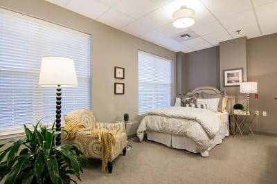 A well-furnished private room with a bed and chair