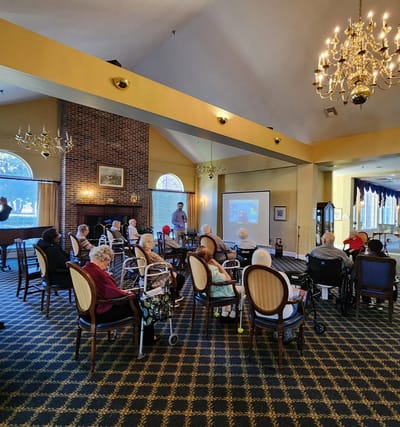 Residents enjoying a presentation in the common area