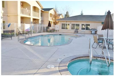 Outdoor pool area with lounge chairs and umbrellas