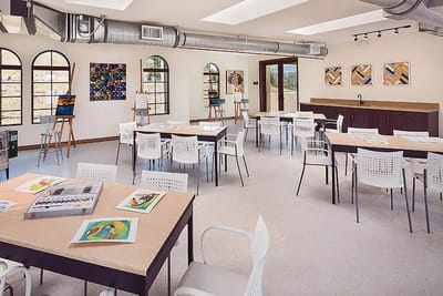 Bright and airy art activity room with empty tables