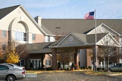 Front entrance of a senior living facility with an American flag