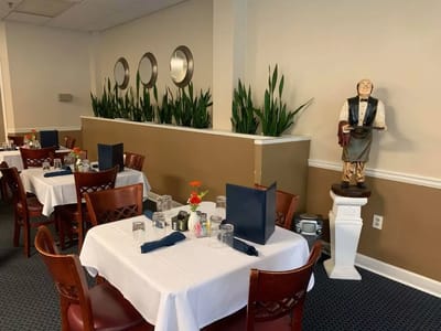 Dining area with neatly set tables and a statue