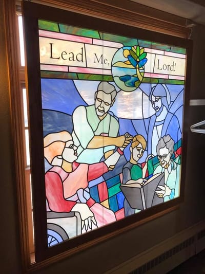 Stained glass window depicting residents and staff together