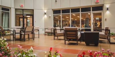 Outdoor seating area with flowers and people visible