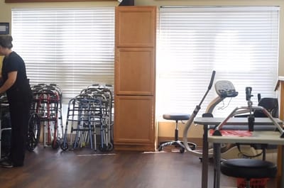 Staff member organizing mobility aids in an activity room