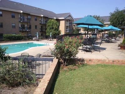 Outdoor pool area with seating and umbrellas