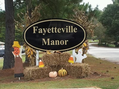 Signage for Fayetteville Manor with seasonal decorations