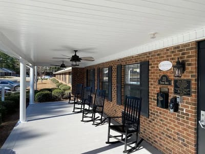 Rocking chairs lined up on a porch at Fayetteville Manor