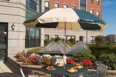 Patio with meals and flowers under an umbrella