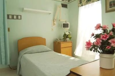 A private resident room with a bed and flowers