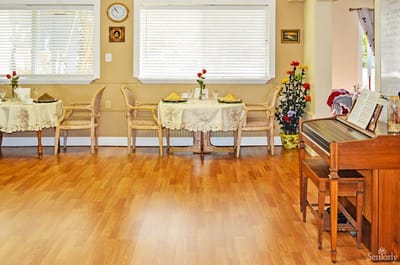 Bright common area with tables and a piano