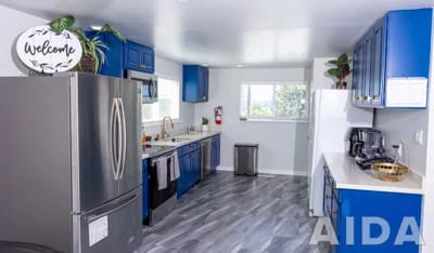 Bright kitchen with welcome sign and blue cabinets