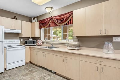 Bright kitchen area with wooden cabinets and appliances