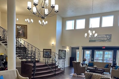Bright lobby area with staircase and chandeliers