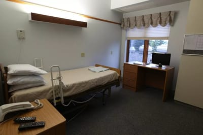 A private resident room with a bed and desk