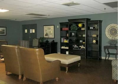 Lounge area with chairs and bookshelf in Meadowview Nursing and Rehab