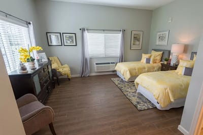 Cozy shared bedroom with yellow decor and natural light