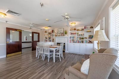 A cozy interior common area with bookshelves and seating