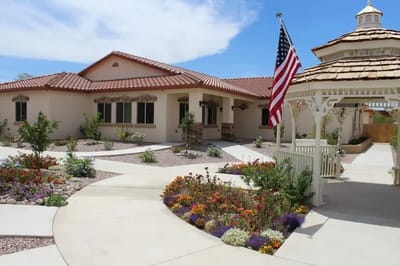 Exterior view of a senior care home with flowers and gazebo