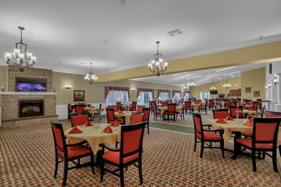 Bright dining area with red chairs and table settings