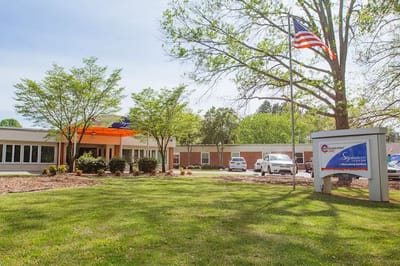 Exterior view of assisted living facility with flag