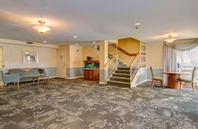 Bright common area with seating and a staircase