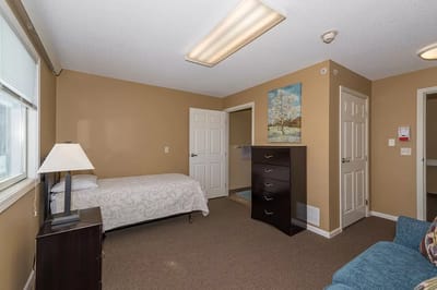 A private resident room with a bed and dresser