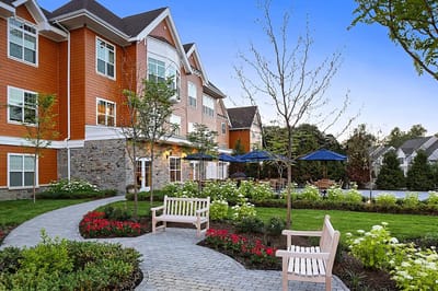 Exterior view of a senior living facility with landscaped gardens