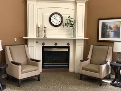 Cozy lounge area with two chairs and a fireplace