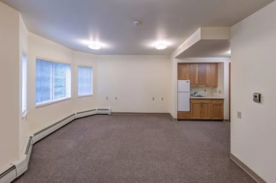 Empty resident room featuring kitchen and windows