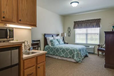 Cozy resident room with a queen-sized bed and kitchenette