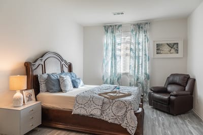 Cozy resident room with a bed and comfortable chair