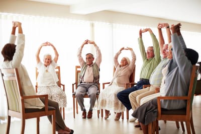 Residents participating in a seated exercise class
