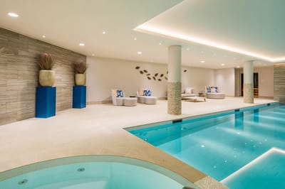 Bright indoor pool area with loungers and decor