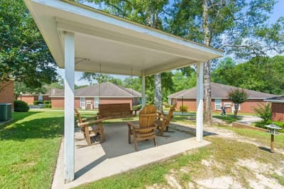 Covered outdoor seating area with chairs and a swing