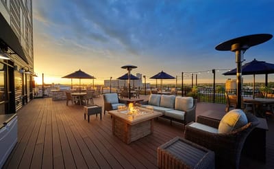 Outdoor terrace with seating and a fire pit at sunset