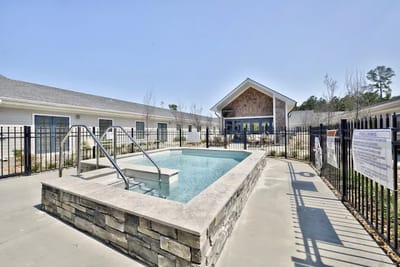 Outdoor pool area with seating and fencing