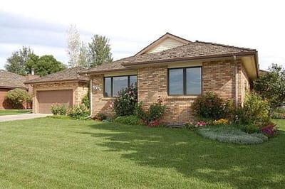 A brick exterior of a single-story house with landscaping