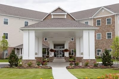 Front entrance of a senior living facility with landscaped walkway