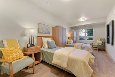 Well-furnished resident room with two beds and natural light