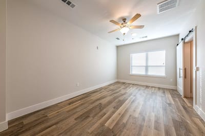 Empty resident room with a ceiling fan and window