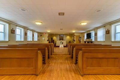 Interior view of a chapel with wooden pews